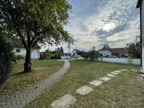 a brick path in a yard with a tree at Kelsbachhaus EG in Pförring
