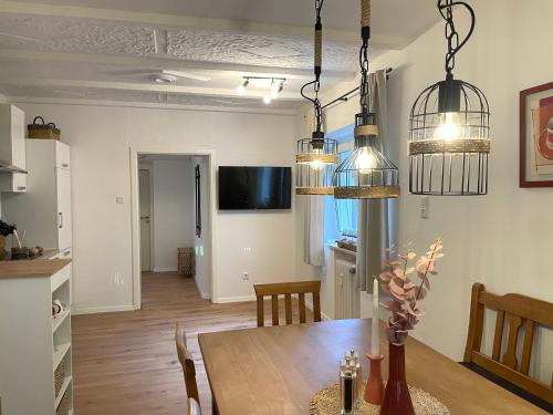 a kitchen and dining room with a table and pendant lights at Kelsbachhaus EG in Pförring