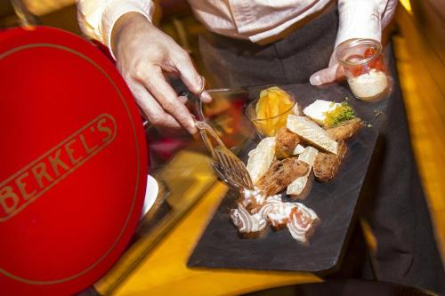 a person cutting a plate of food on a table at Komfort Appartements serviced by Auhof in Kaprun