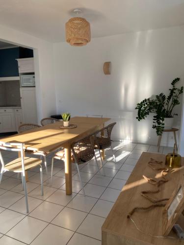 uma sala de jantar com uma mesa de madeira e cadeiras em Beure maison chaleureuse et cosy em Beure