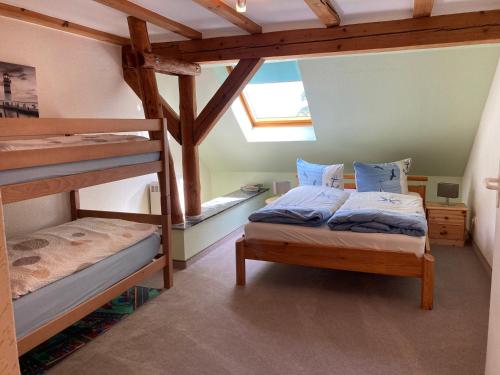 a bedroom with two bunk beds and a window at Landhausidyll Ferienwohnung in Grundshagen