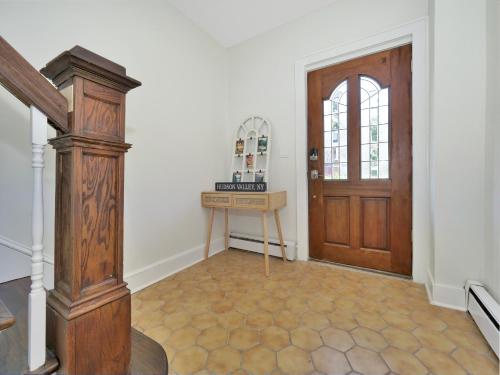 a hallway with a wooden door and a table at Deck View of Hudson River & Mt Beacon / Boho Suite in Newburgh