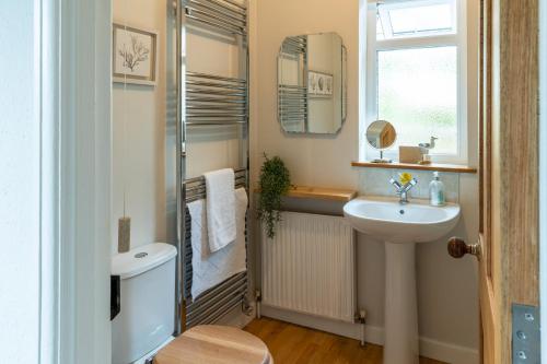 La salle de bains est pourvue d'un lavabo, d'un miroir et d'une douche. dans l'établissement Finest Retreats - Tideway, à Saint Clement