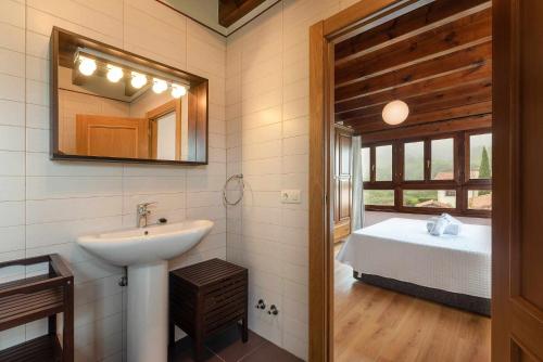 a bathroom with a sink and a mirror and a bed at Villa Vacacional Villahormes in Naves