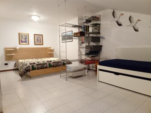 a room with a bed and a bedroom with birds on the wall at Appartamento - terrazzo vivibile vista mare, wi-fi gratuito in Vallecrosia