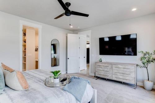 a bedroom with a bed and a flat screen tv at Midway to Heaven! BRAND NEW 5 bed 4.5 bath, HOTTUB in Midway