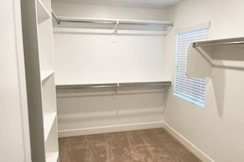 a walk in closet with a window and white walls at Midway to Heaven! BRAND NEW 5 bed 4.5 bath, HOTTUB in Midway