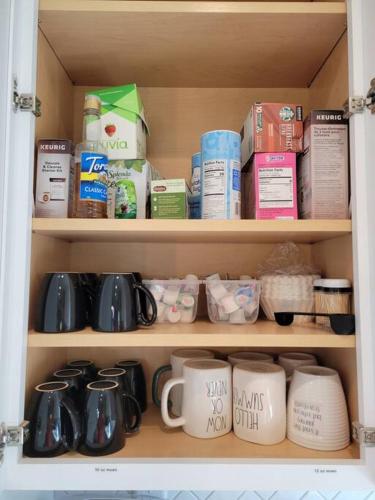 a cupboard filled with mugs and other food items at Midway to Heaven! BRAND NEW 5 bed 4.5 bath, HOTTUB in Midway