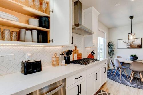 a kitchen with white cabinets and a counter top with a table at Midway to Heaven! BRAND NEW 5 bed 4.5 bath, HOTTUB in Midway