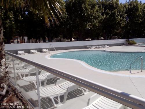 uma piscina com espreguiçadeiras e uma piscina em mobil home 001 em Agde