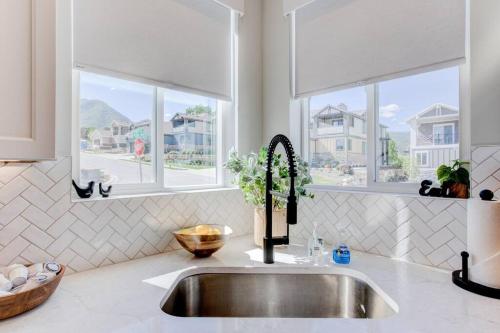 a kitchen counter with a sink and two windows at Midway to Heaven! BRAND NEW 5 bed 4.5 bath, HOTTUB in Midway
