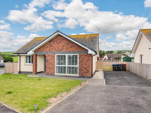 a brick house with a driveway in a yard at Oystercatcher in Drummore