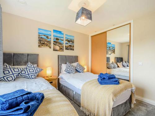 a bedroom with two beds and a mirror at Oystercatcher in Drummore