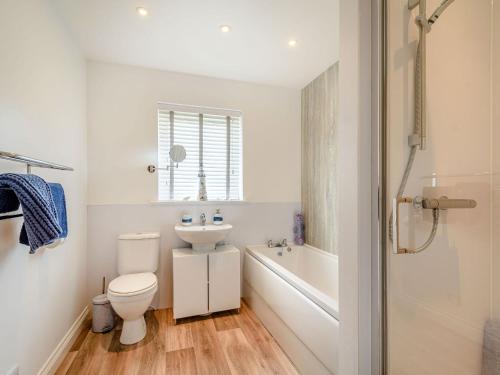 een badkamer met een toilet, een wastafel en een bad bij Oystercatcher in Drummore