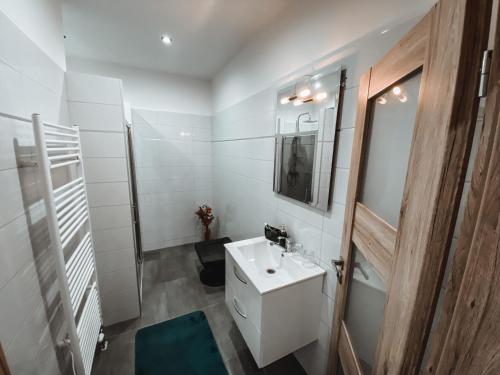 a white bathroom with a sink and a toilet at Cozy B&B Home in Banská Bystrica
