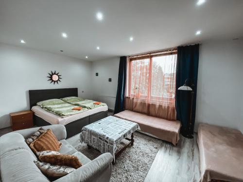 a living room with a couch and a bed at Cozy B&B Home in Banská Bystrica