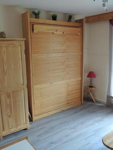 einen Schrank mit einer Holztür in einem Zimmer in der Unterkunft F2 Le Corbier aux pieds des pistes, commerces et esf in Le Corbier