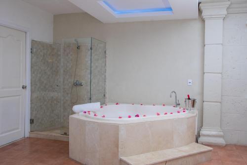 y baño grande con bañera y ducha. en Aparthotel Castillo Real, en Punta Cana