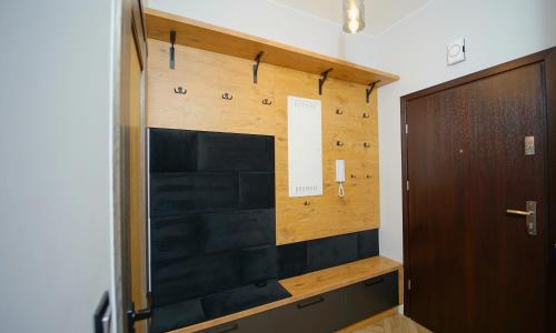 Cette chambre est dotée d'un mur en bois et d'une porte. dans l'établissement Apartamenty EverySky - Mickiewicza 30, à Jelenia Góra