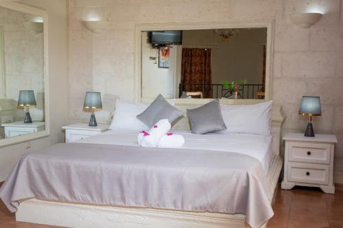 Una cama blanca con un animal de peluche. en Aparthotel Castillo Real en Punta Cana