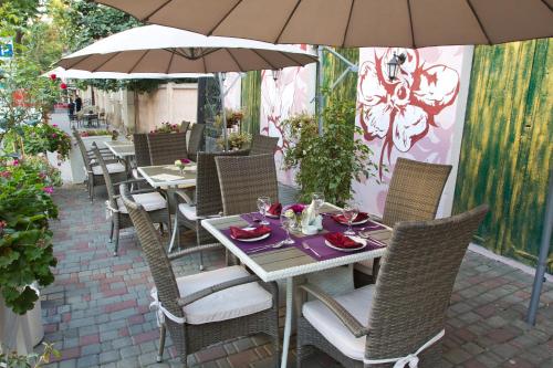 a table and chairs with an umbrella on a patio at Boutique Hotel California in Odesa