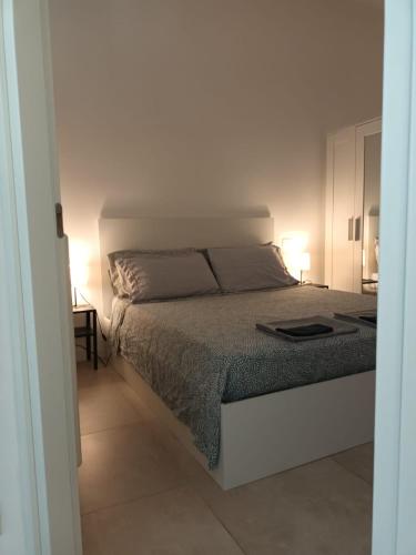 a white bedroom with a bed and two lamps at B&B Lido Apartament 10A in Civitanova Marche