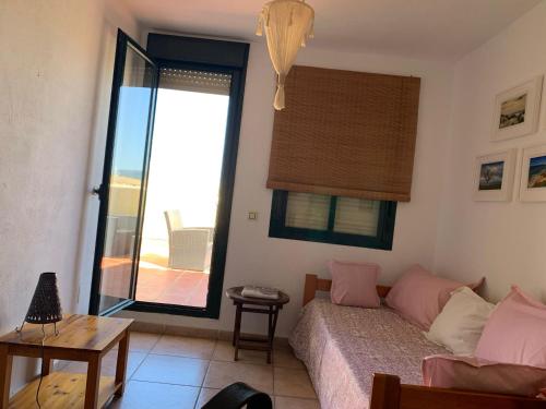 1 dormitorio con 1 cama y ventana con balcón en ATICOS Primera Linea en ZAHARA DE LOS ATUNES, en Zahara de los Atunes