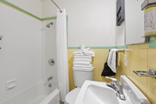a bathroom with a sink and a toilet and a tub at Crown Motel in Kings Beach
