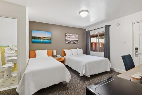 a hotel room with two beds and a sink at Crown Motel in Kings Beach