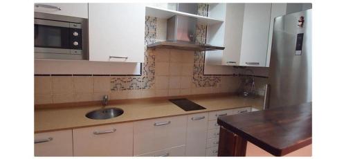 a kitchen with a sink and a microwave at ATICOS Primera Linea en ZAHARA DE LOS ATUNES in Zahara de los Atunes
