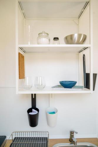 a kitchen cabinet with dishes and bowls on it at Seafront Holidays & Workstays in Molfetta