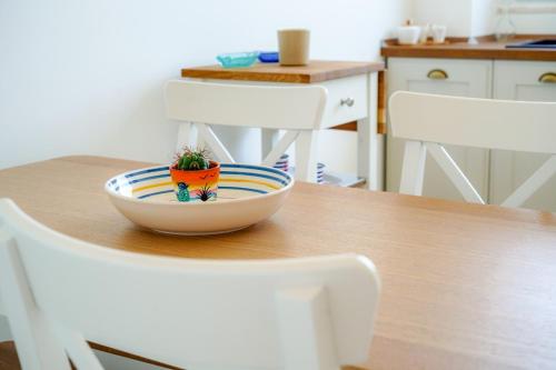 a bowl on a table with two white chairs at Seafront Holidays & Workstays in Molfetta
