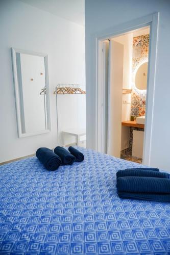 a bedroom with a blue bed with pillows on it at Seafront Holidays & Workstays in Molfetta
