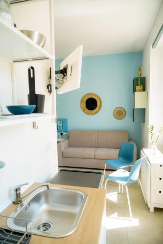 a kitchen and living room with a sink and a couch at Seafront Holidays & Workstays in Molfetta