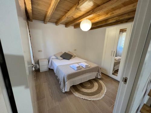- une petite chambre avec un lit et un plafond en bois dans l'établissement Casa de piedra Barreiriña, à A Coruña