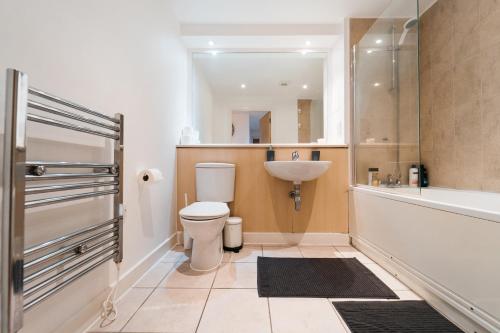 a bathroom with a toilet and a sink and a tub at Lovely 2 bedroom flat next to Victoria Park in London