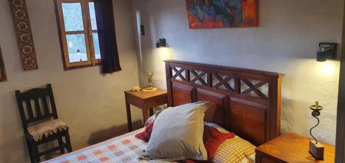 a bedroom with a bed and a table and a window at Karallantay in Tilcara