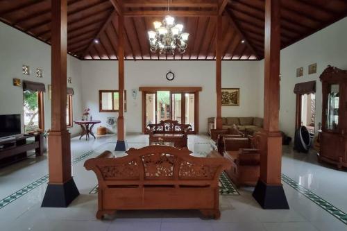 a large living room with a couch and a chandelier at Griya Bayan Kraguman Vila 2 Kamar Tidur 