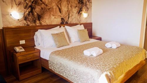 ein Schlafzimmer mit einem Bett mit zwei Handtüchern darauf in der Unterkunft Hotel Villa Letan in Fažana