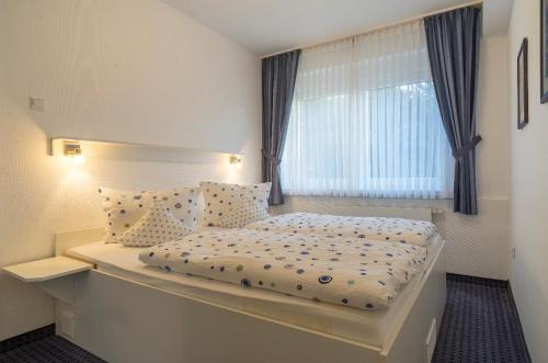 a small bedroom with a bed and a window at Haus Kleemann in Norderney