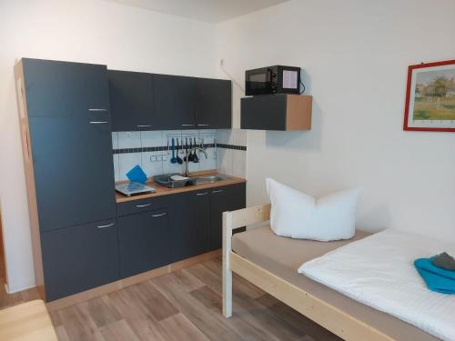 Habitación pequeña con cama y escritorio. en City Pension Senftenberg / Apartment Nr.2 en Senftenberg