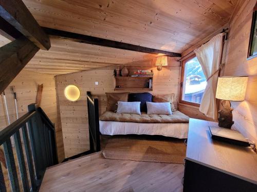 - une chambre dans une cabane en rondins avec un lit et un bureau dans l'établissement Chalet de Charme aux Gets - 6 Pers, 3* avec Navette pour les Pistes et Jardin Privatif - FR-1-598-96, aux Gets