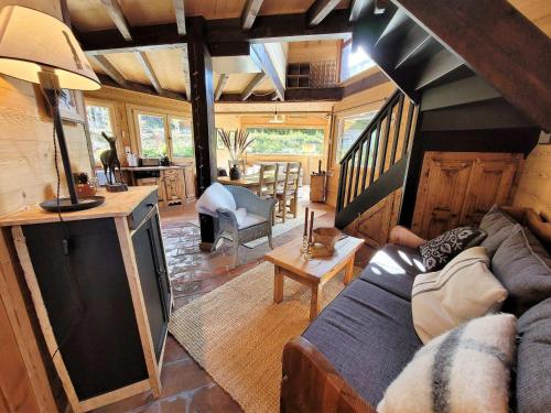 un salon avec un canapé et une télévision dans l'établissement Chalet de Charme aux Gets - 6 Pers, 3* avec Navette pour les Pistes et Jardin Privatif - FR-1-598-96, aux Gets