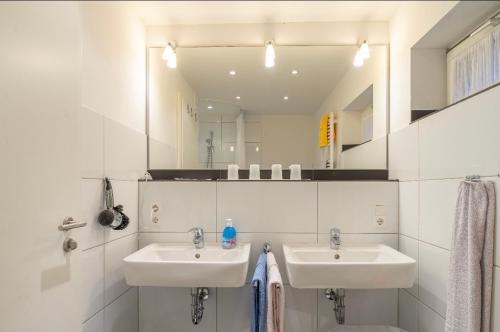 a bathroom with two sinks and a large mirror at Haus Kleemann in Norderney