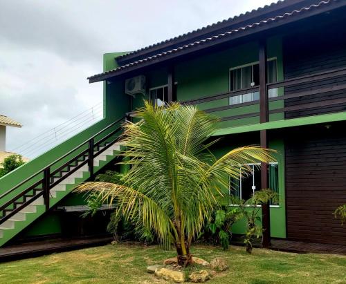una palmera frente a un edificio verde en Morada Flores de Alaíde - Pinheira, en Pinheira