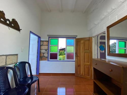 a room with stained glass windows and a chair at Cabañas y Flores in Jericó