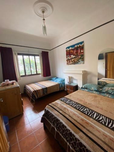 a hotel room with two beds and a window at La Chocita Ward in Lima