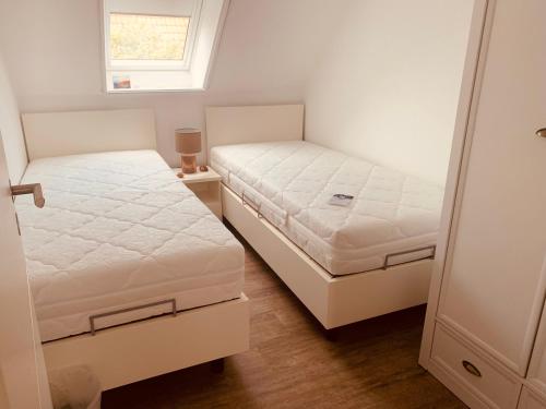フェーマルンにあるOstseebrise-Fehmarnのベッドルーム1室(ベッド2台、窓付)