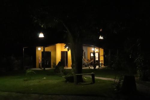 a house at night with a tree in the yard at Casa Recanto das Mangueiras Japaratinga - Alagoas in Japaratinga