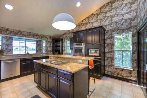 a kitchen with black cabinets and a stone wall at Sanibel Sunrise in Captiva